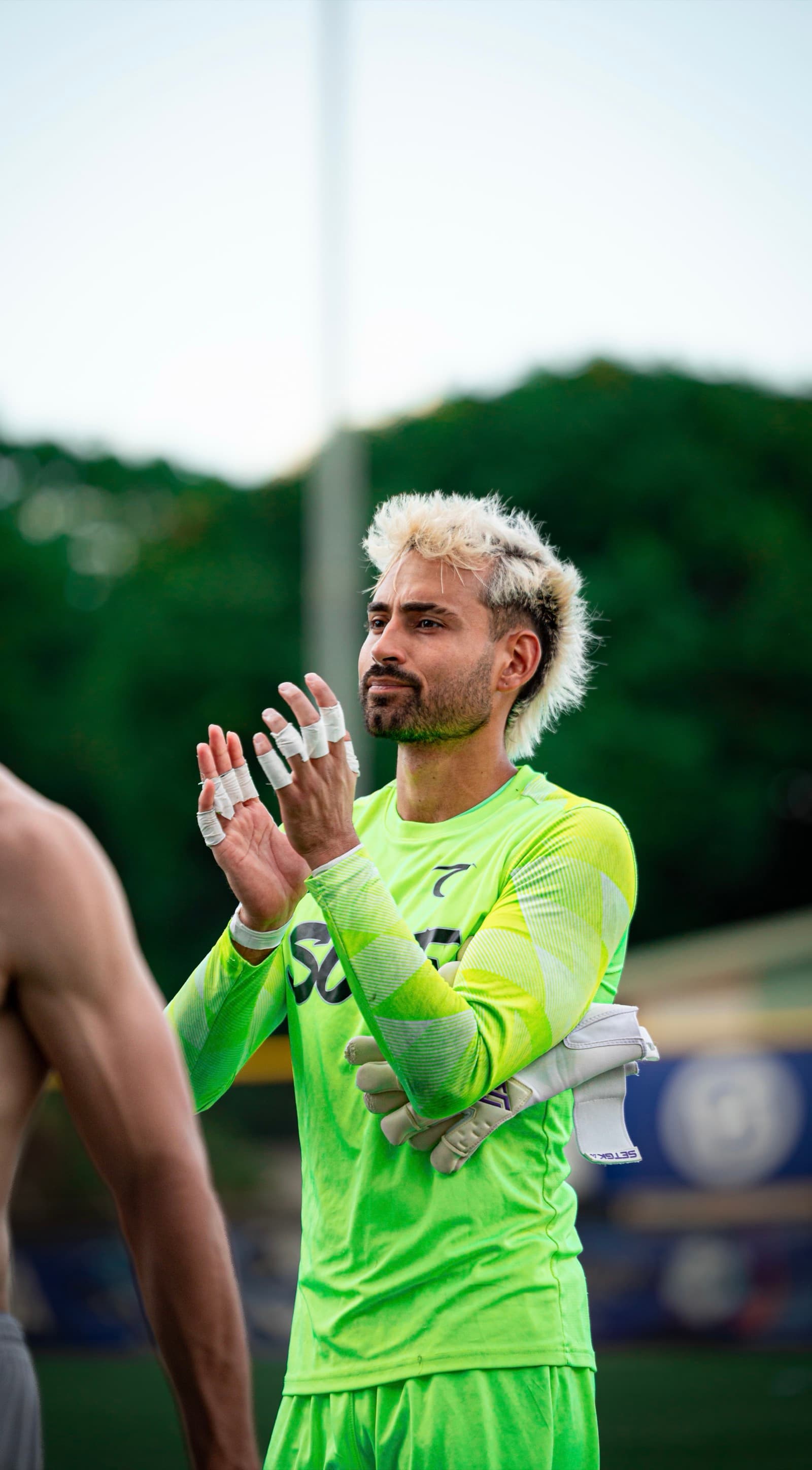 Lucas Espada applauding supporters after a match at sunset